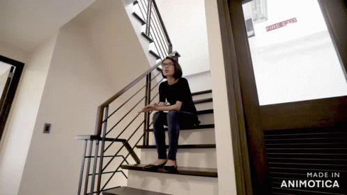 a woman standing at the bottom of a stair case