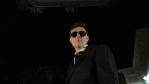 a blue skeleton wearing sunglasses and a black suit