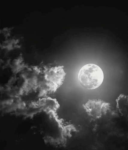 the moon is shining above a dark clouds
