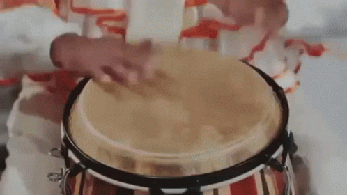 a small child is playing on a drum with an animal