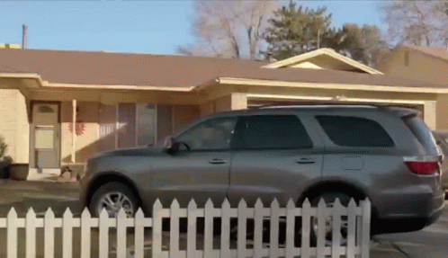 an suv is parked in front of the house
