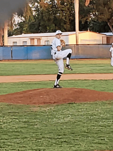 pitcher throwing a baseball from a mound while on his knees