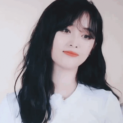 a woman with long black hair wearing a white shirt