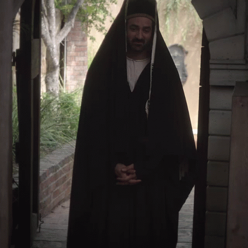 a person in a dark outfit standing on a walkway