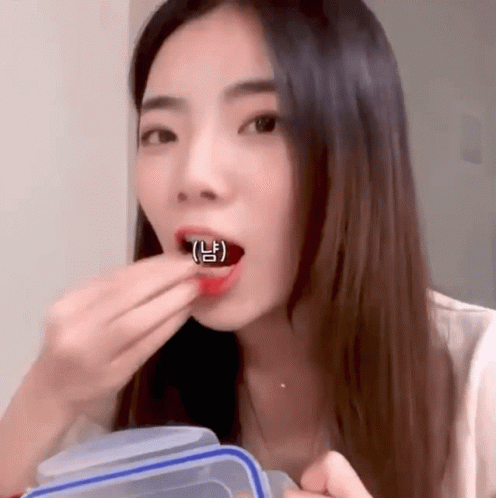 asian girl using plastic spoon to feed her teeth