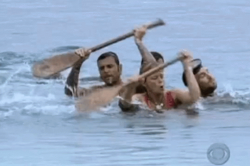 two people standing in the water with their paddles on their back