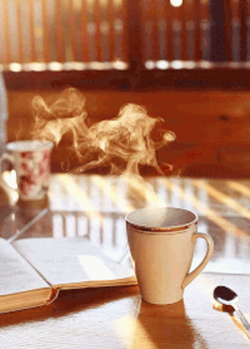 a cup with smoke rising from it on top of a glass table
