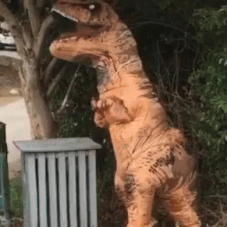 a fake dinosaur standing up against a fence