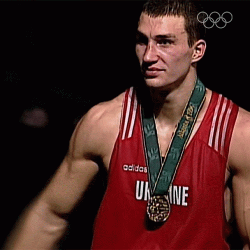 a man holding his shirt open with medal around his neck