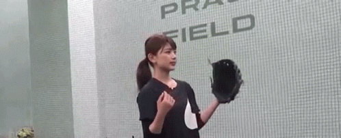 a woman is throwing a baseball in a glove