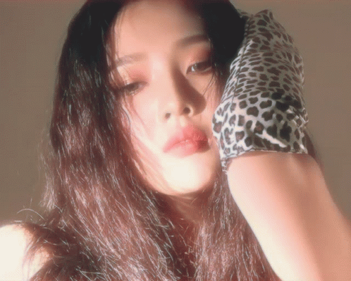 a young asian woman with dark hair wearing a black  with cheetah print sleeve