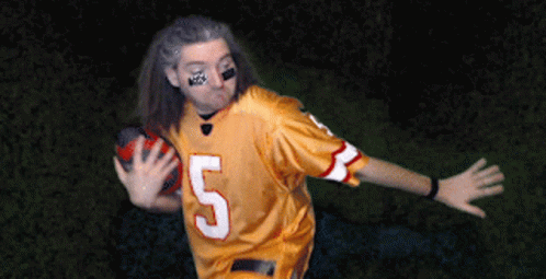 an attractive woman wearing a football uniform and painted face