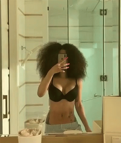 woman with black  taking selfie in mirror