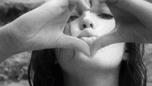 a woman making the shape of a heart with her hands
