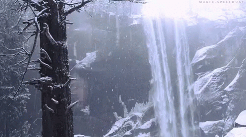 a person riding a snow board next to a waterfall
