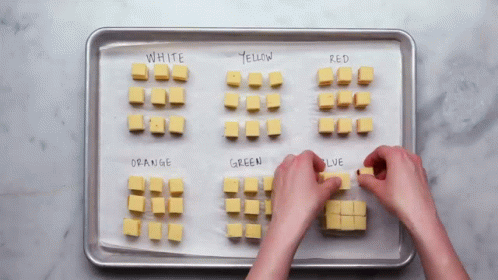 two hands are on a tray with cubes and writing on them