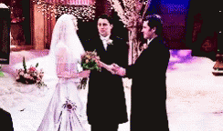 the bride and groom are in black suits with white veils
