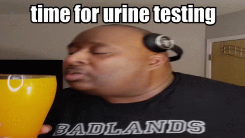 a man holding a blue cup that says time for urine testing