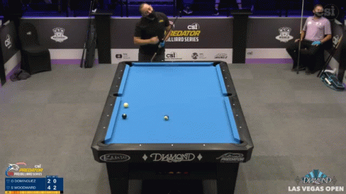 an outdoor pool table in an arena with spectators looking on