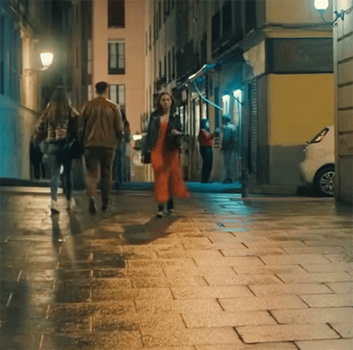 people walking down an urban street at night