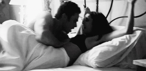 black and white pograph of two people in a bed