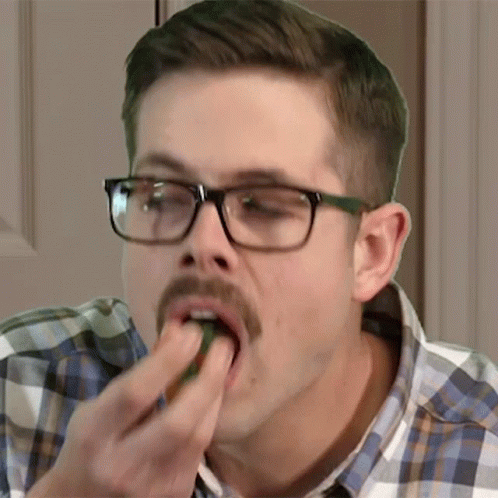 a young man is taking a bite out of food