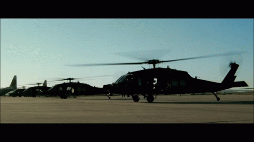 the military helicopter is black and grey at night