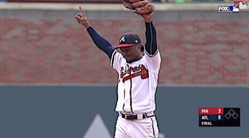 the baseball player raises his arms in the air