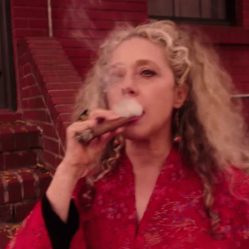 a young woman is blowing smoke on her face