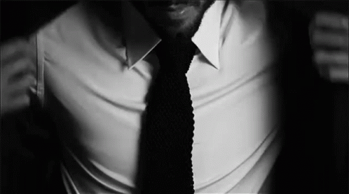 a black and white picture of a man wearing a white shirt with a tie