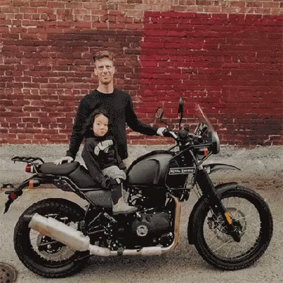 a man and boy are posing on the motorcycle