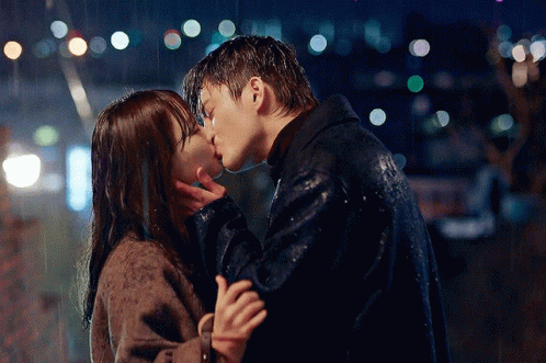 the man and woman are kissing in the rain