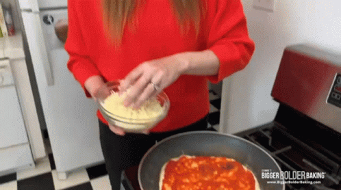 a woman in a blue sweater and a pan of food