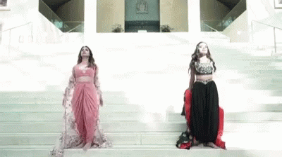 three beautiful woman in long gowns walking down steps