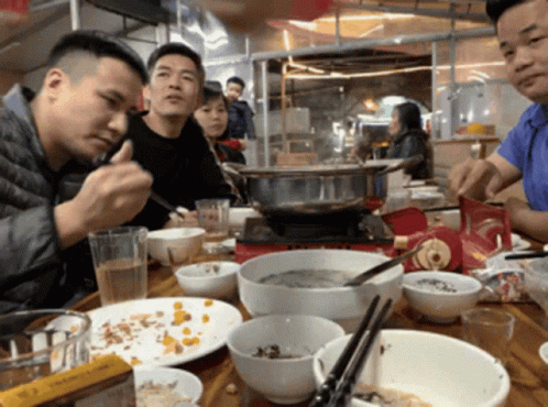 a group of asian men are enjoying dinner together