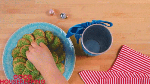 a child's hand in a bowl on top of broccoli