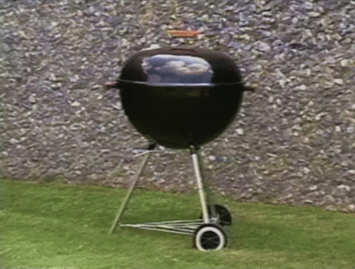 there is a grill that is in the grass