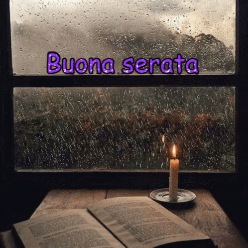 the word buona serata on a window sill in front of a book and a lit candle