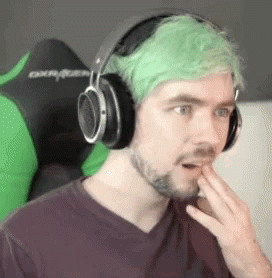 man with bright green hair and headphones on