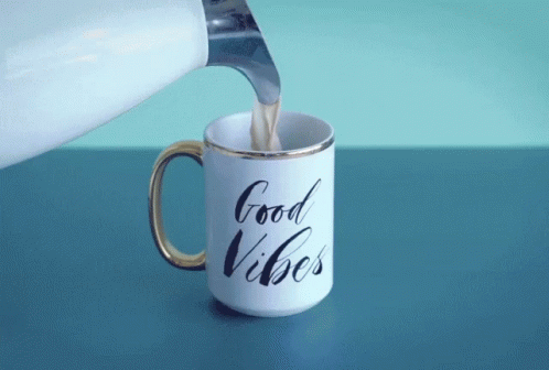 someone pouring soing into a cup with good vibes on it
