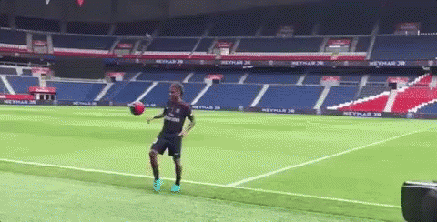 a man plays soccer on a green field in a stadium