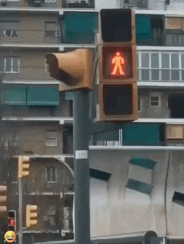 a pedestrian sign stands near some building that is blurry