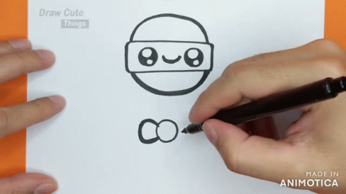 the hand draws a drawing on the paper with a marker