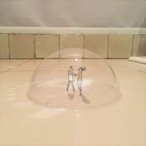a po of two people in front of a bowl of soing that is clear and has little lines on it