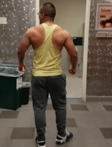 a man is in the bathroom, with his back turned