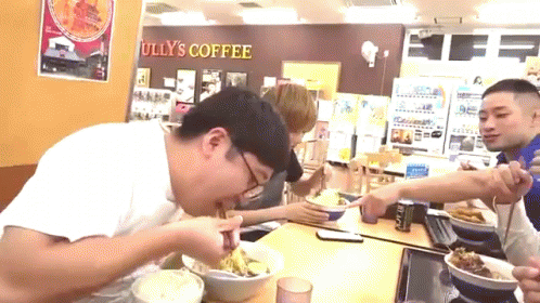 two men in a store eating a meal