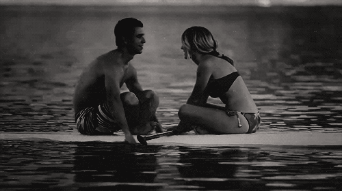 a woman and a man in swimwear sitting on a raft