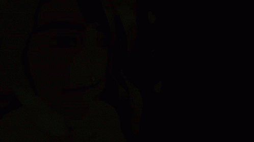 a woman with her hair up standing in the dark
