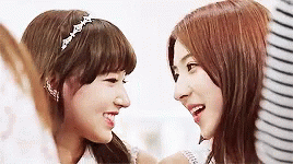 two asian girls laughing with each other in the background