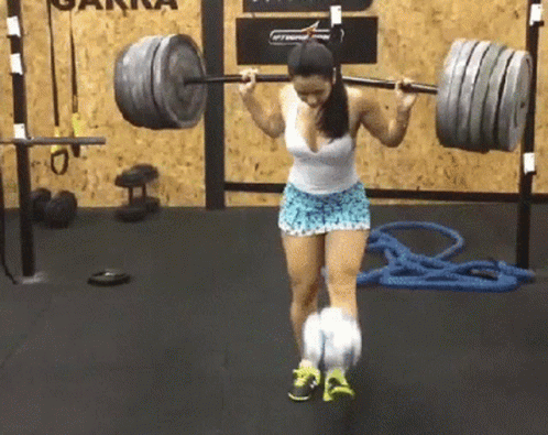 woman in sports clothing lifting barbells with rope